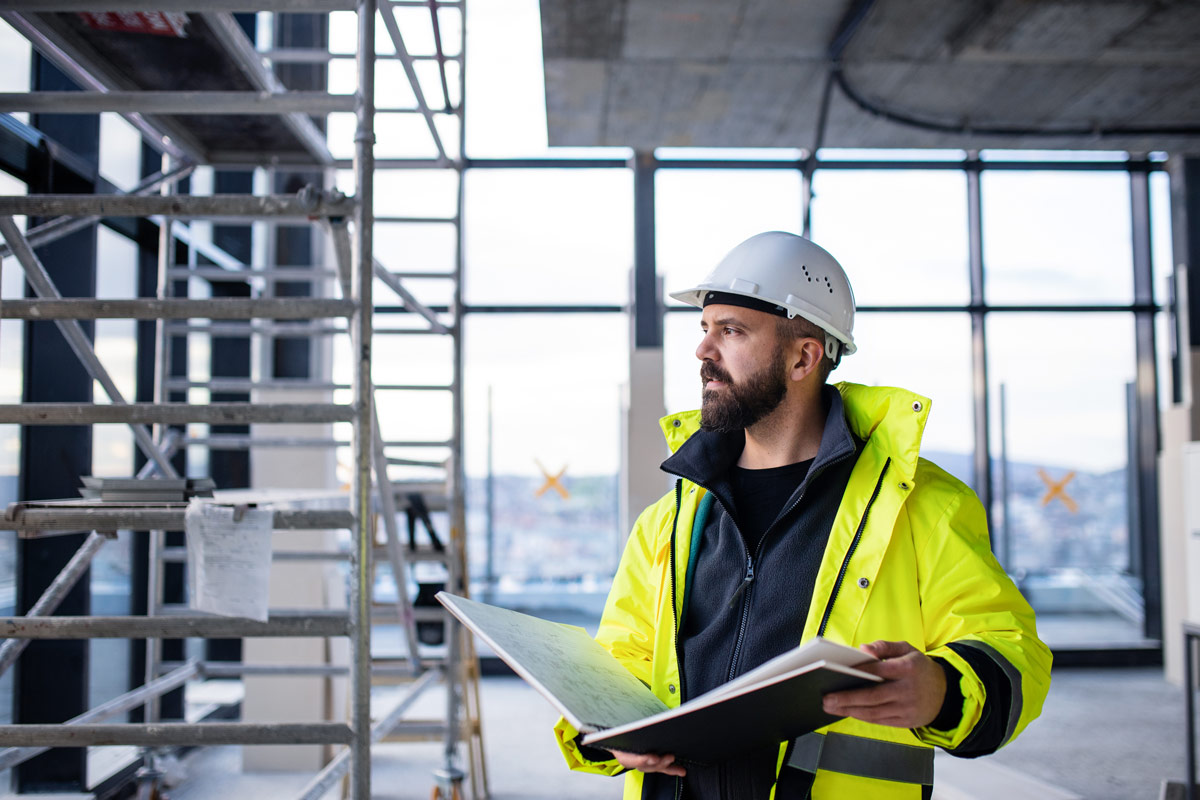 sentral-godkjenning-fornye Ansatt i bygg- og anleggsbransjen ser utover byggeplass.